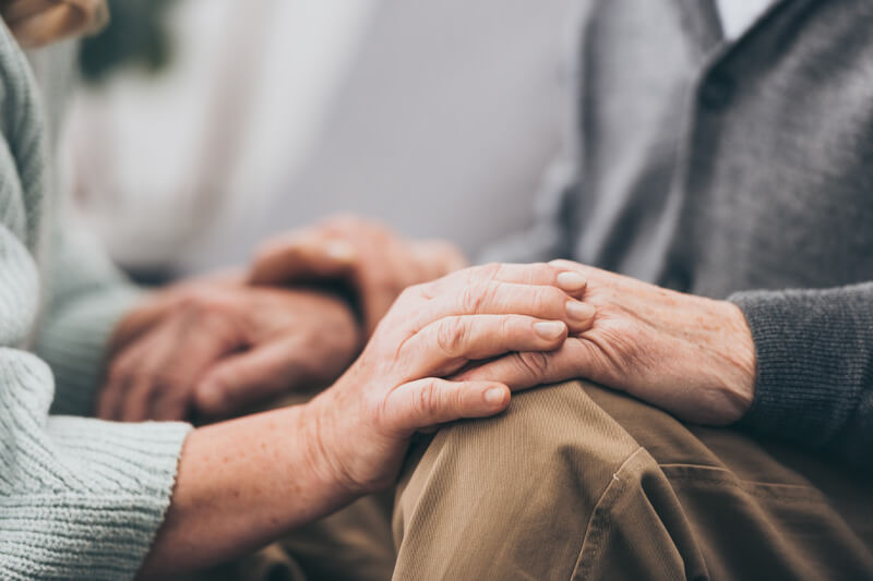 Elder couple holding hands in hands