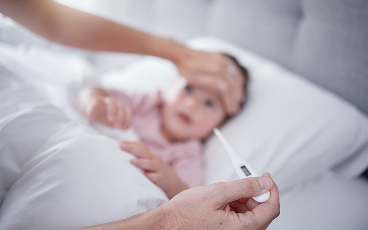 Woman measuring child's fever